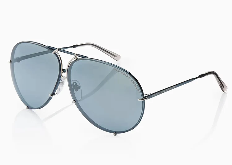 A pair of aviator-style sunglasses from Porsche Design with blue-tinted lenses and thin metal frames, displayed on a white background—an ideal pick for any 2025 Holiday Gift Guide.
