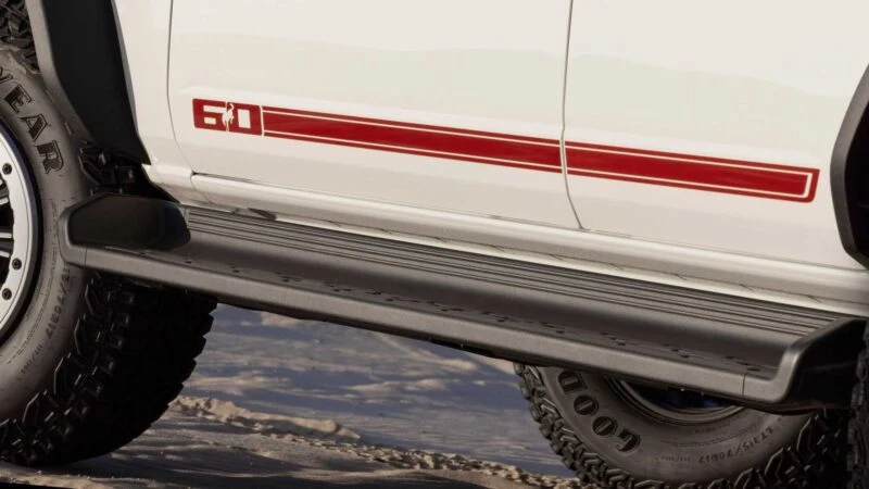 Close-up of a white vehicle’s side displaying a red